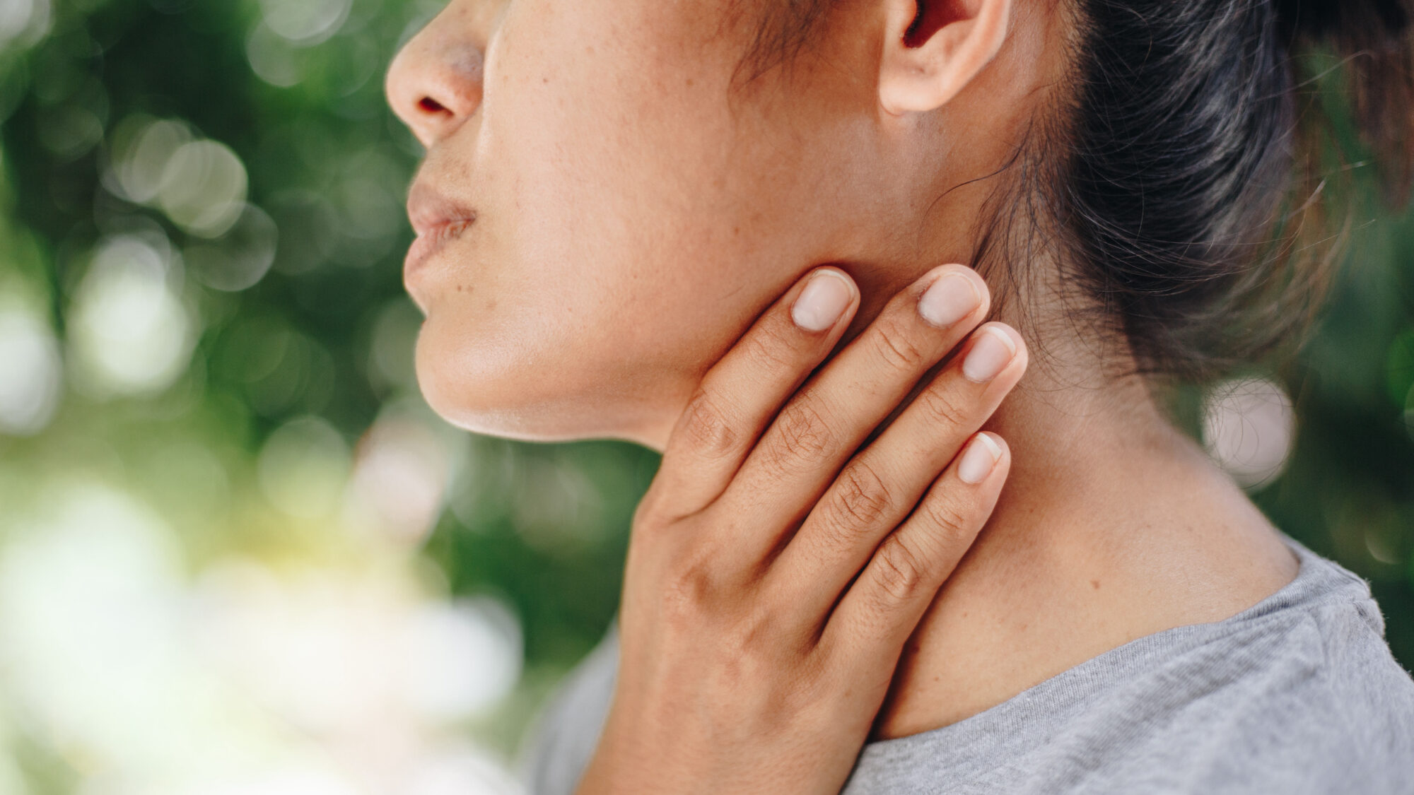 Woman with sore throat touches neck wonder if it is head and neck cancer | cCARE | San Diego & Fresno, CA
