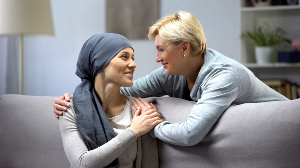 Woman comforting woman with cancer